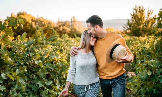 Emotionally fulfilled couple walking through a park smiling and having a great time